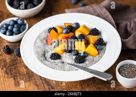 Bol de lait de Chia avec baies et fruits sur fond de table rustique en bois. Concept de dieting, manger propre Banque D'Images