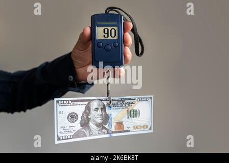 Billets en dollars sur les balances électroniques, symbole de la réduction des coûts, de l'inflation, de la dépréciation de l'argent. Concept d'inflation aux États-Unis d'Amer Banque D'Images