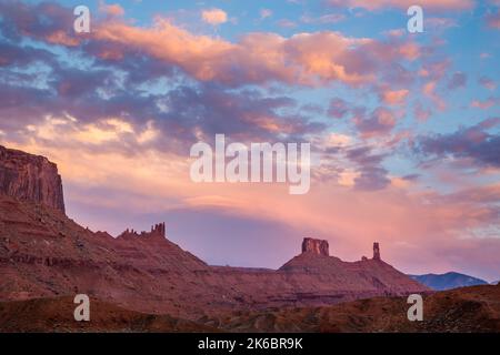 Coucher de soleil nuages sur mère supérieure, le presbytère et Castleton Tower / Castle Rock, près de Moab, Utah. Banque D'Images