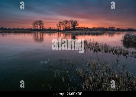 Un coucher de soleil coloré sur un lac gelé Banque D'Images