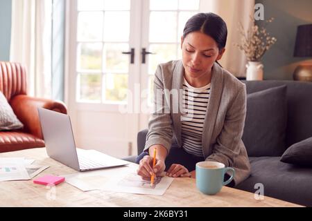 Femme architecte ou décorateur d'intérieur travaillant à domicile regardant les conceptions sur ordinateur portable Banque D'Images