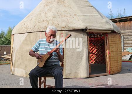 Jouer à un Komuz traditionnel fait à la main, Ak-Orgo Workshop, Barskoon, Issyk Kul région, Kirghizistan, Asie centrale Banque D'Images