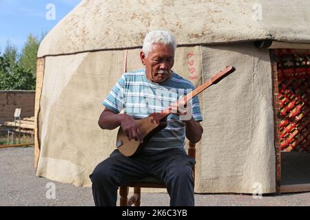 Jouer à un Komuz traditionnel fait à la main, Ak-Orgo Workshop, Barskoon, Issyk Kul région, Kirghizistan, Asie centrale Banque D'Images