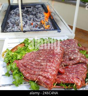 Plateau avec saucisses prêtes à être cuites sur le gril. Banque D'Images