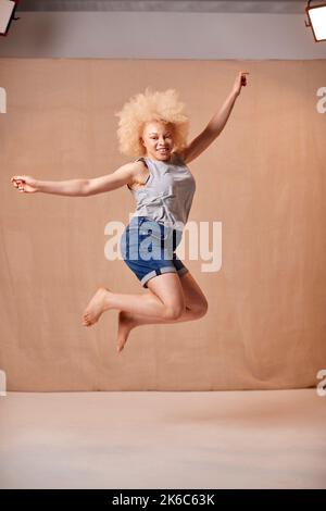 Studio Portrait de la femme Albino positive corps qui saute dans l'air Banque D'Images