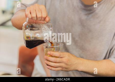 Le barista verse du café dans des verres à emporter dans le café-restaurant. Banque D'Images