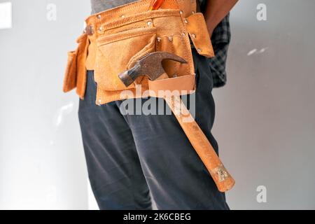 Gros plan court d'un homme portant une ceinture porte-outils avec des outils pour le bricolage à la maison Banque D'Images