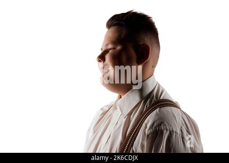 Bonne humeur. Garçon souriant, modèle en surpoids en chemise blanche et bretelles isolées sur fond blanc de studio. Concept de la jeunesse, des émotions, du visage Banque D'Images