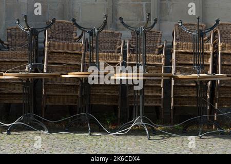 06 octobre 2022, Basse-Saxe, Osnabrück: Les chaises et les tables d'un restaurant extérieur sont soigneusement empilées et fermées avec un câble métallique. Photo: Friso Gentsch/dpa Banque D'Images