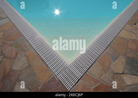 Piscine d'été avec eau bleue et reflet du soleil Banque D'Images