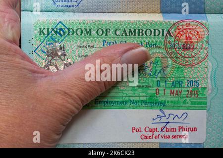 Main tenue passeport ouvert avec Royaume du Cambodge Visa en passeport britannique Banque D'Images