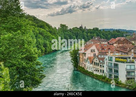 Vue aérienne de la rivière claire Aare à Berne, Suisse avec une forêt luxuriante sur une rive, maisons suisses typiques de l'autre côté montre un lifesyl détendu Banque D'Images