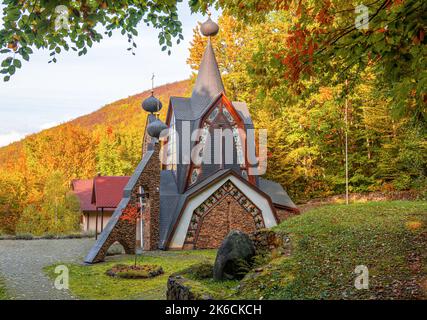 La construction de l'Église orthodoxe dans le contexte de la forêt d'automne. Banque D'Images