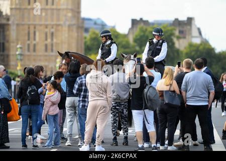 2 officiers de police montés en métropole surpassent le pont de Westminster à Londres. Le jour 1 Reine couché dans l'État.Arrêt pour interagir avec les membres du public. Banque D'Images