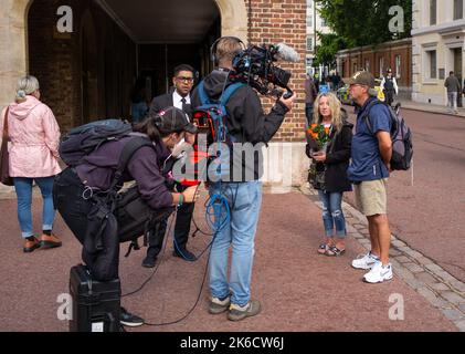 Une équipe de presse télévisée interviewer des membres du public en visite à Londres au Royaume-Uni le premier jour de la Reine dans l'État de Windsor Hall. Banque D'Images