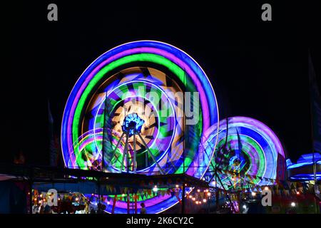 Éclairage coloré superposé sur la roue de ferris en rotation. Événement culturel Sekaten. Surakarta, Indonésie. Banque D'Images