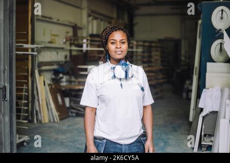 Portrait d'une femme peintre confiante portant un masque de protection à l'extérieur de l'atelier Banque D'Images