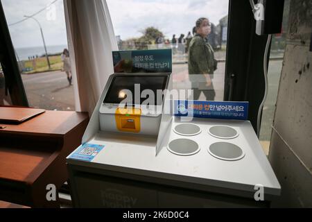 Jeju. 13th octobre 2022. Photo prise le 13 octobre 2022 montre un appareil réutilisable de recyclage de tasse dans un café de l'île Udo de Jeju, en Corée du Sud. Udo a récemment lancé une campagne de protection de l'environnement en offrant aux touristes des tasses réutilisables. Les tasses réutilisables peuvent être recyclées par les installations et réutilisées après avoir été nettoyées et désinfectées. Crédit : Wang Yiliang/Xinhua/Alay Live News Banque D'Images