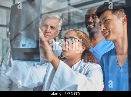 Qu'en pensez-vous ? un groupe de professionnels de la santé qui regardent une radiographie lors d'une réunion dans la salle de conférence de l'hôpital. Banque D'Images