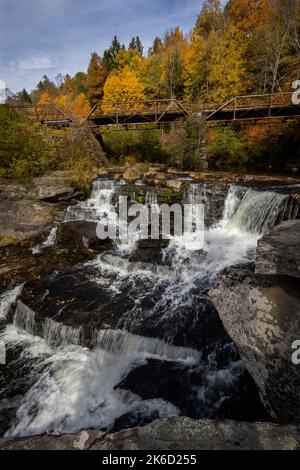 Tanners Falls dans le Poconos près de Honesdale, PA, lors d'une brillante journée d'automne, qui comprend plusieurs cascades et un pont historique Banque D'Images