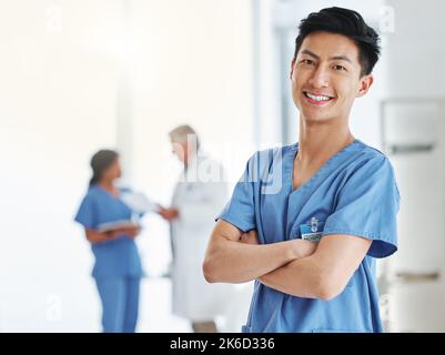 Fournir des soins est bénéfique pour tous. Portrait d'un jeune médecin debout avec ses bras croisés dans un hôpital. Banque D'Images