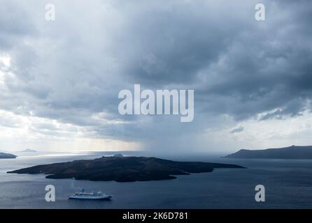 Vue de l'île de Santorini sur la mer Égée montrant un bateau de croisière. Banque D'Images