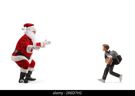 Un écolier court pour embrasser le père noël isolé sur fond blanc Banque D'Images