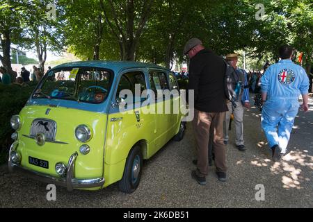 Un homme dans les salopettes de mécanicien Alfa Romeo marchant au-delà de 1950s Fiat Multila BARC Revival Meeting, circuit automobile de Goodwood, Chichester, Sussex, Royaume-Uni Banque D'Images