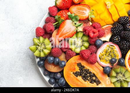 Fruits délicieux sur fond blanc, framboises à la mangue grenade papaye oranges fruits de la passion baies, sélectif, vue de dessus Banque D'Images