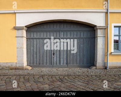 Grande porte d'entrée en bois dans un ancien bâtiment. Porte d'une cour intérieure assez grande pour les voitures. Architecture dans une zone rurale. Planches de bois altérées. Banque D'Images