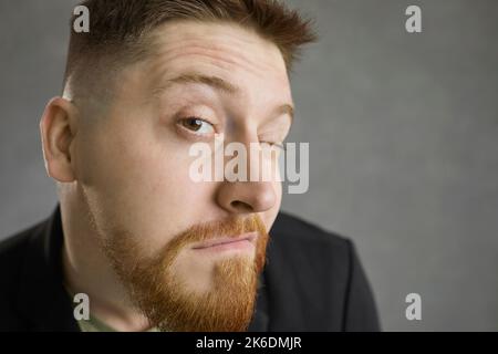 Gros plan de drôle curieux homme regardant vous avec l'expression du doute et de la suspicion Banque D'Images