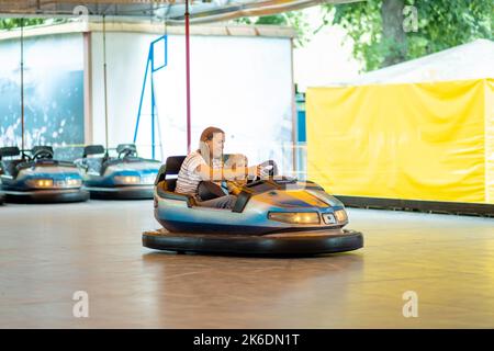 Mère et fils ayant fait le tour dans la voiture de pare-chocs au parc d'attractions Banque D'Images