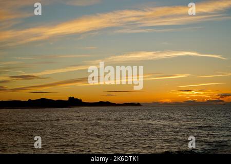 Coucher de soleil sur la mer au-dessus du château de Bamburgh Banque D'Images