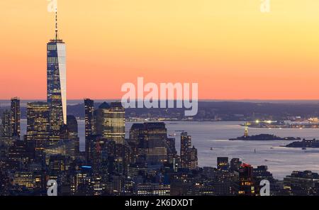 Vue aérienne des gratte-ciel de Lower Manhattan illuminée au coucher du soleil sur fond orange à New York, États-Unis Banque D'Images