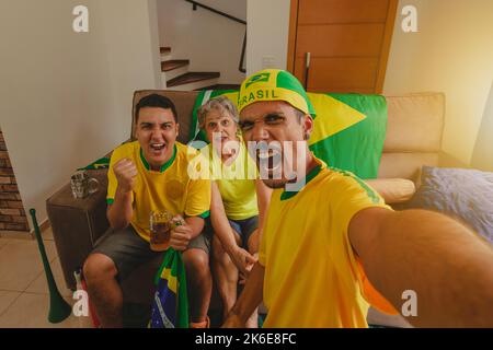 Brazilian Mixed Race Family célébrant la coupe dans le salon en regardant un match de football. Banque D'Images