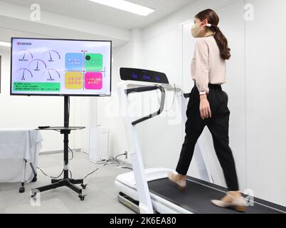 Tokyo, Japon. 13th octobre 2022. Le géant japonais de l'électronique, Kyocera, se déplace sur un tapis roulant pour présenter le système de détection et d'entraînement de la compagnie avec trois capteurs portables d'écouteur, de bracelet et d'anklet à Tokyo jeudi, 13 octobre 2022. Le système de détection de la marche mesure la posture à l'aide de petits capteurs et fournit un diagnostic et un coaching en temps réel par le biais d'un écouteur. Credit: Yoshio Tsunoda/AFLO/Alay Live News Banque D'Images