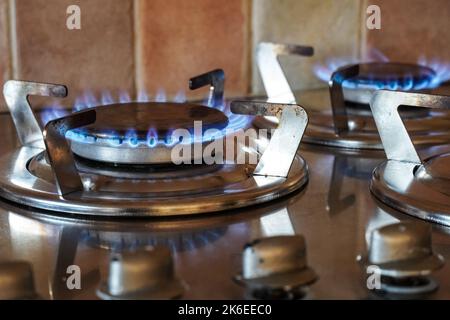 Flammes de gaz bleues qui brûlent sur un brûleur de table de cuisson à gaz, cuisinière à gaz de cuisine Banque D'Images