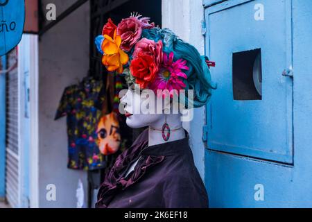 Mannequin avec fleurs colorées sur sa tête à l'extérieur d'un magasin Banque D'Images