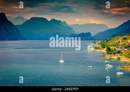 Au-dessus du lac de Garde idyllique avec des voiliers à Malcesine au coucher du soleil, alpes italiennes Banque D'Images