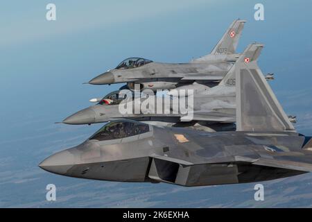 Lask, Pologne. 12th octobre 2022. A ÉTATS-UNIS Un avion de chasse F-22 de la Force aérienne affecté à l'escadron de combat expéditionnaire 90th effectue une mission de protection aérienne de l'OTAN avec deux chasseurs F-16 de la Force aérienne polonaise, à 12 octobre 2022 près de Lask, en Pologne. Credit: SSgt Danielle Sukhlaall/US Air Force/Alay Live News Banque D'Images