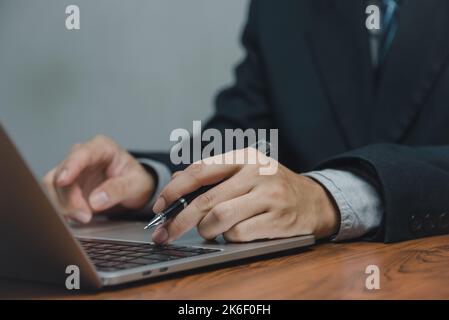 Gros plan homme travaillant et tapant sur ordinateur portable clavier travail à domicile, télétravail, concept d'apprentissage en ligne. Banque D'Images