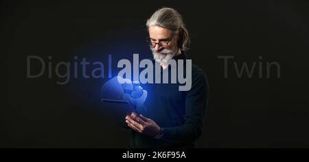 Homme d'affaires senior avec une tablette et sa projection numérique sur fond sombre. Concept de jumeau numérique Banque D'Images