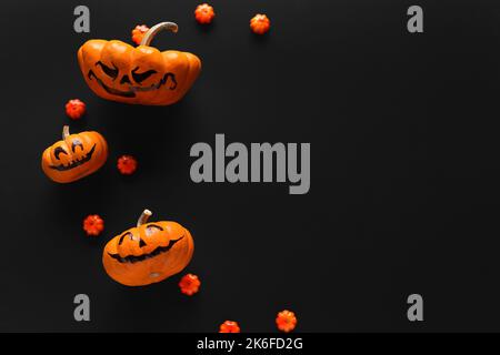 Citrouilles d'Halloween avec visages dessinés sur fond sombre Banque D'Images