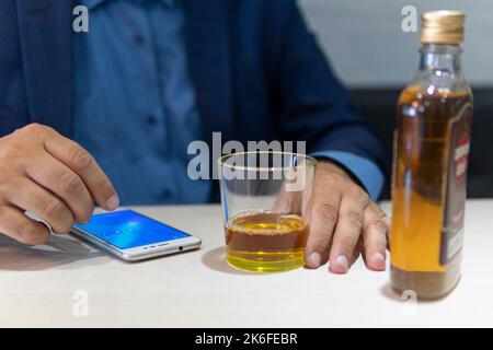 alcoolisme, dépendance à l'alcool et concept de personnes - homme alcoolique avec une bouteille de rhum à la maison. Un spécialiste au chômage qui s'est seul ivre hors de son tunnel Banque D'Images