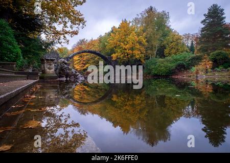 Le Kromlau Azalea et le parc Rhododendron en automne, la sculpture se reflétant sur l'eau, Allemagne, Banque D'Images