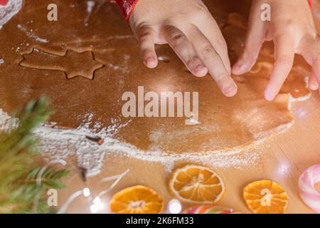 Gros plan les mains des enfants font des biscuits au gingembre de Noël. Banque D'Images