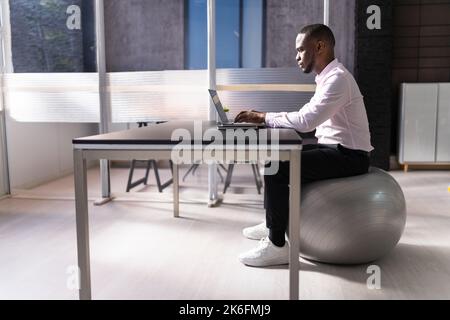 Posture correcte au bureau au bureau à l'aide d'un ballon de fitness Banque D'Images