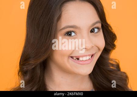 Parce que tout le monde voit votre sourire. Petite fille souriant sans dent de bébé. Un enfant heureux souriant sur fond jaune. Sourire aux dents. Grandissent avec Banque D'Images