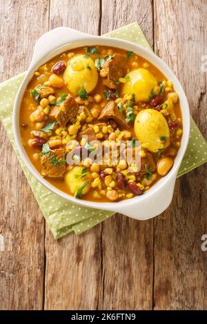 Plat principal traditionnel juif Cholent Hamin pour le déjeuner Shabbat, bœuf lentement cuit avec des pommes de terre, des haricots, des œufs bruns, de l'orge dans la casserole sur la t Banque D'Images