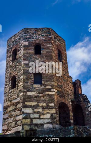 Vue à angle bas de la tour byzantine construite en pierre avec ouvertures de fenêtre contre le ciel bleu. Banque D'Images